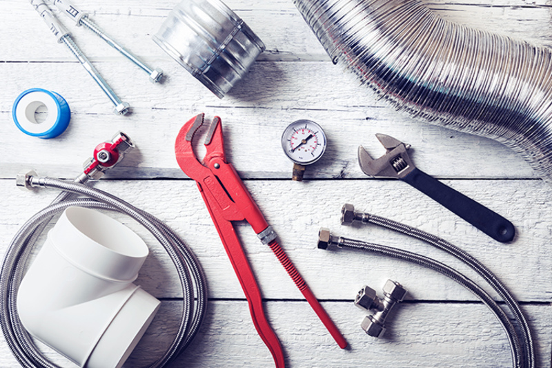 plumbing tools and accessories on wooden table.
